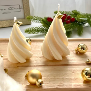 Bougies sapin spirale blanches, décorées avec des ornements dorés et une branche de sapin, créant une atmosphère chaleureuse et festive.