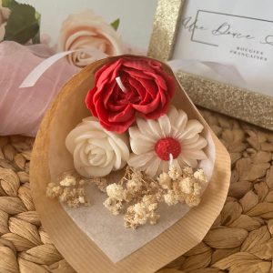 Bouquet de bougies 3 fleurs blanc et rouge posé sur un plateau en osier.